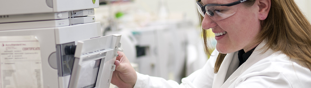 A young scientist in glases adjusts laboratory equipment.