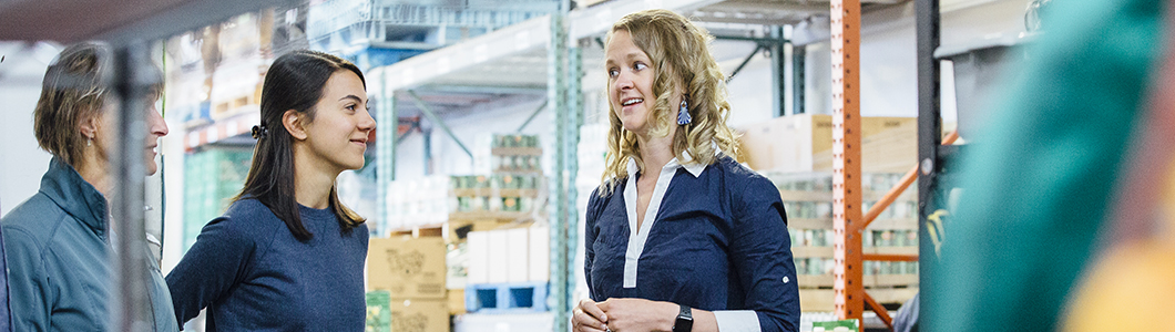 A group of students talk in a food warehouse.