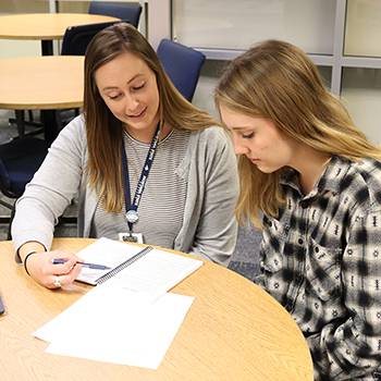 staff member explaining paperwork to a student 