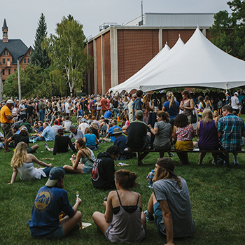 big outdoor event with white tents and hundreds of students