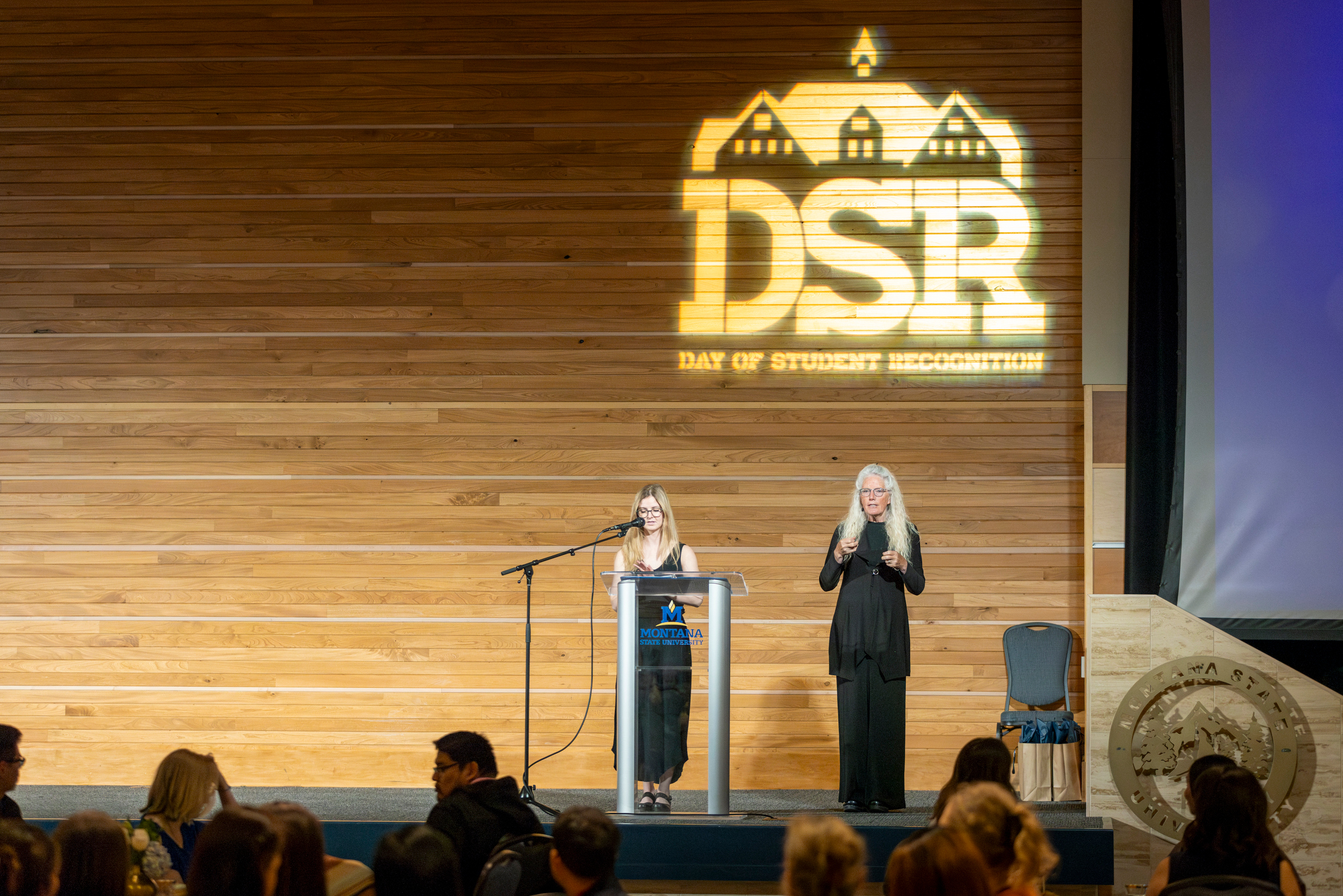 Emcee and Signer on stage at the Day of Student Recognition