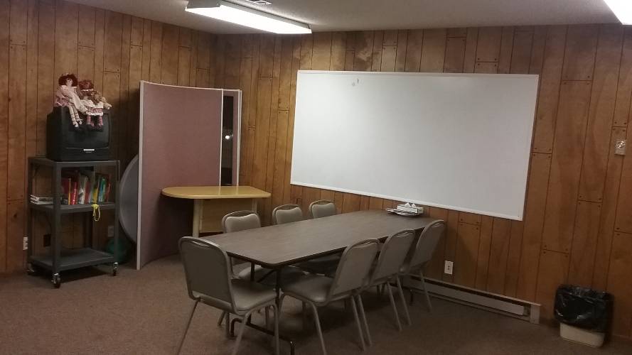 room with table, chairs, and white board