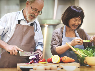 senior couple chopping vegetables