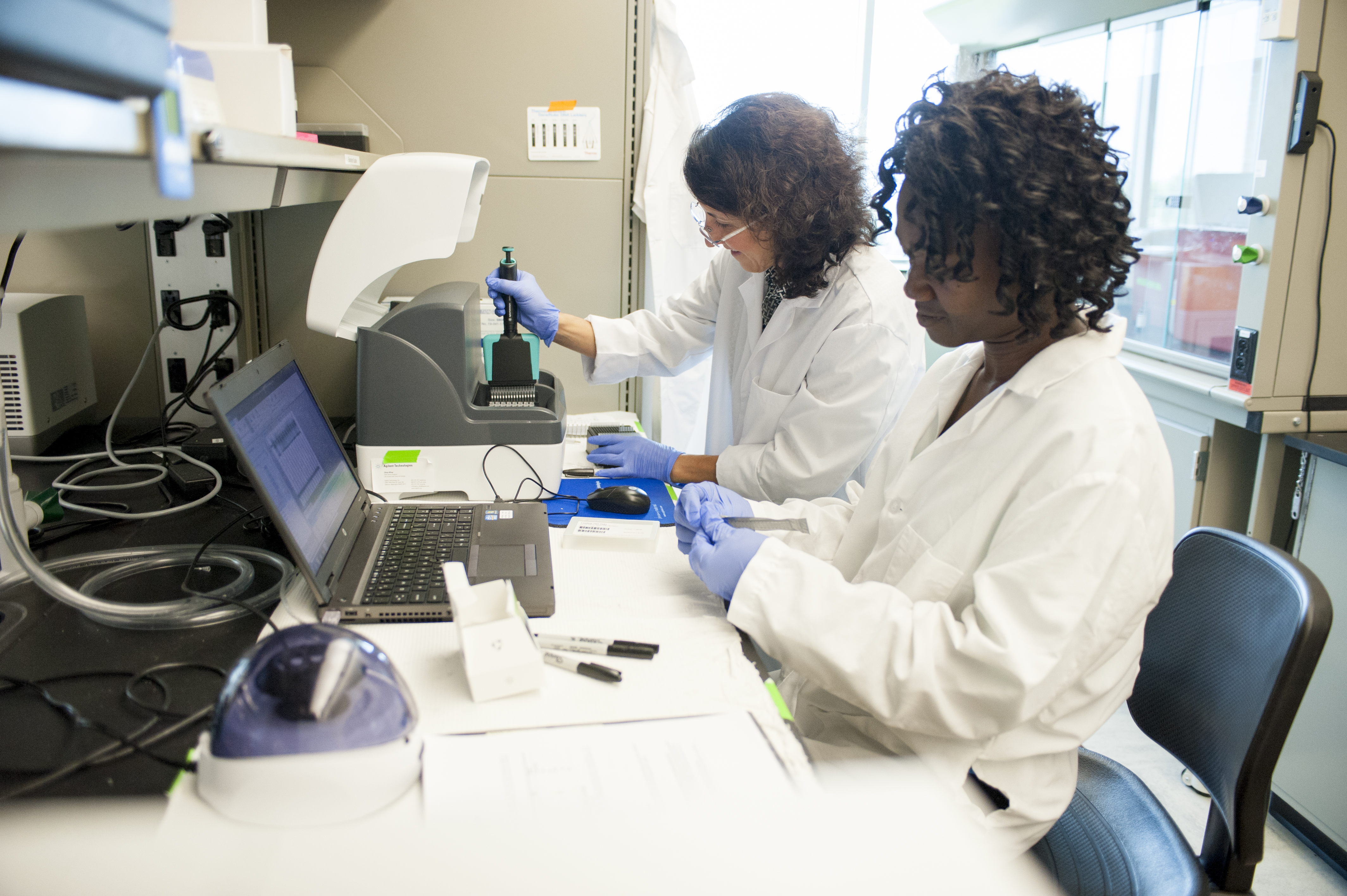 two female researchers working with electrical equipment