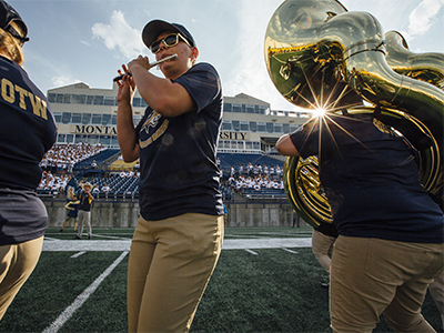 Spirit of the West band members perform on the football field